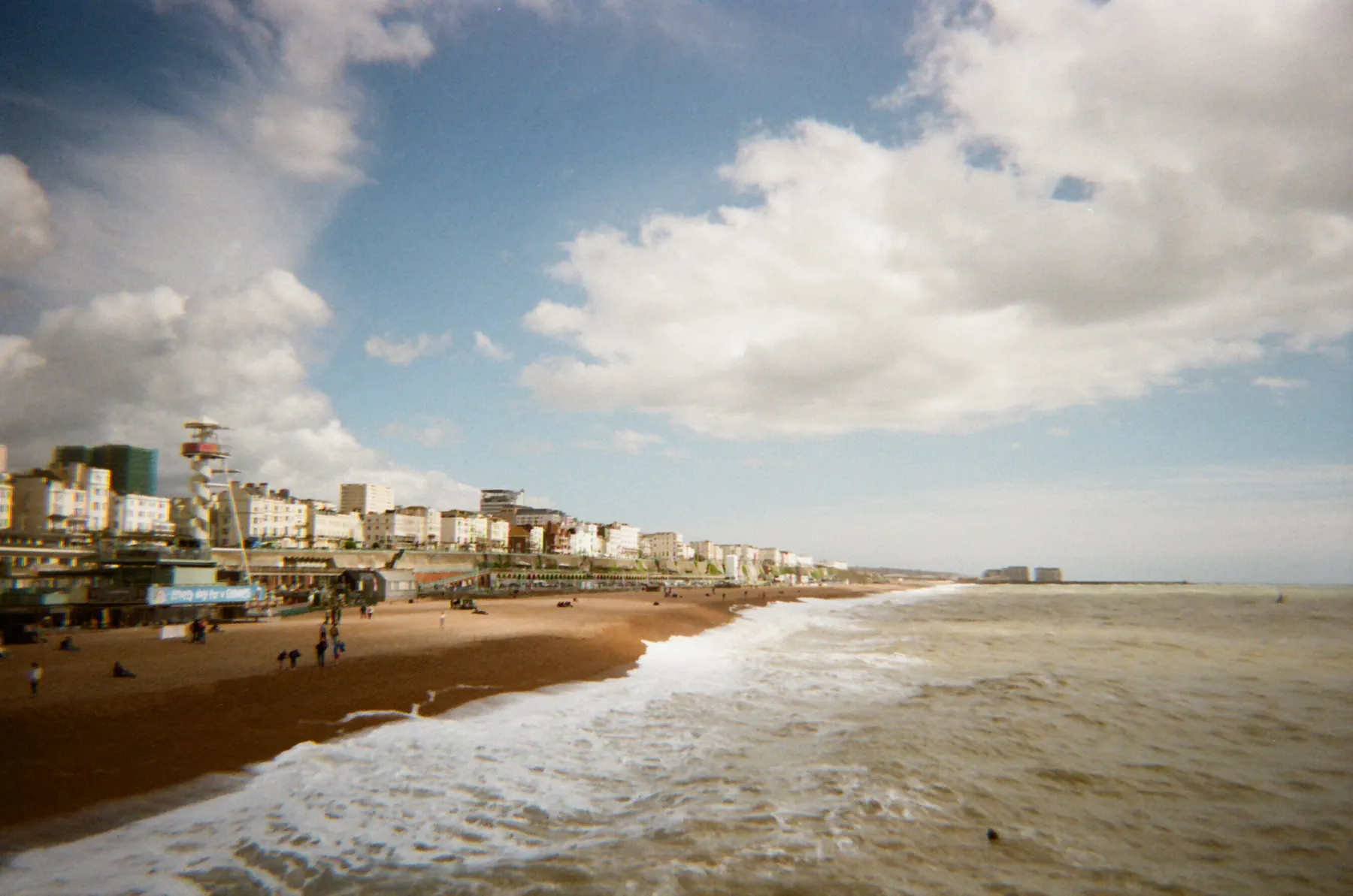 Clouds above a long beach and incoming surf