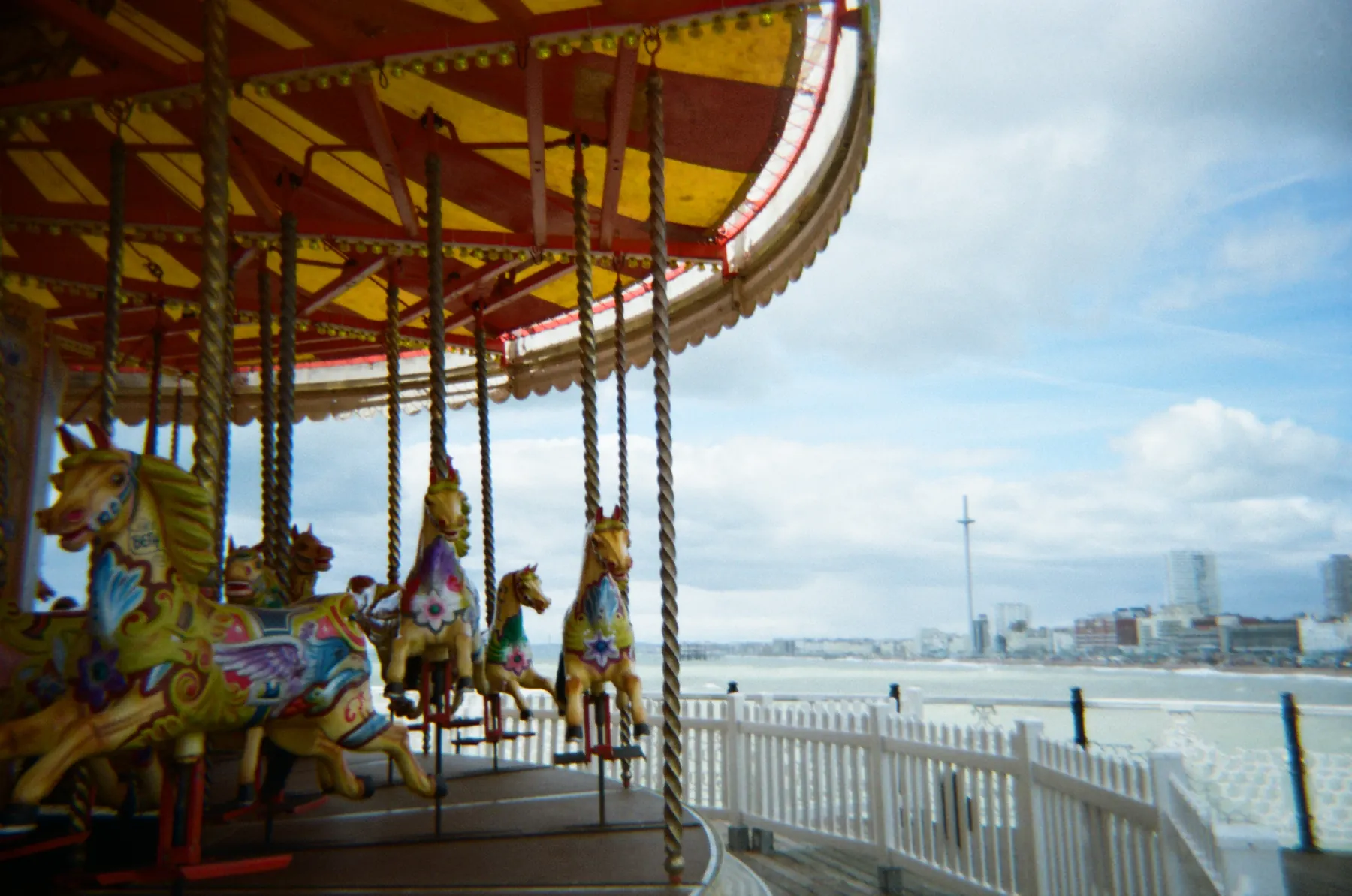 Colourful seaside carousel horses beside a bright coast